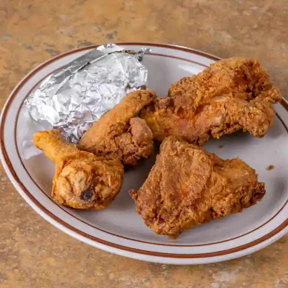 Crispy fried chicken pieces served with a foil-wrapped roll
