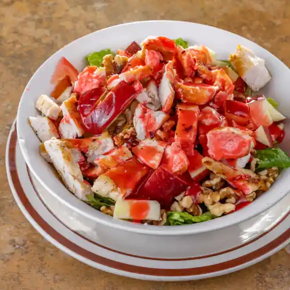 Fresh salad with diced tomato, feta cheese, and walnuts