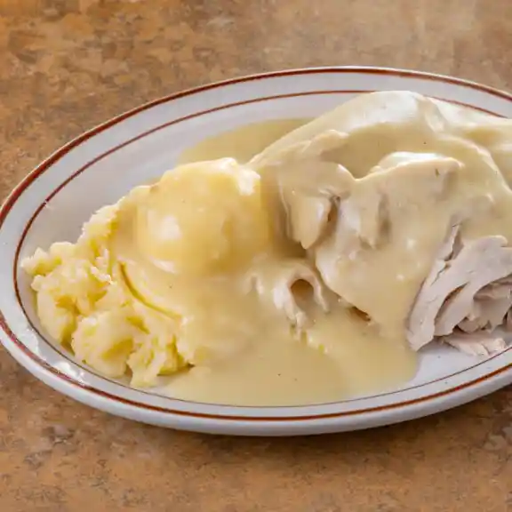 Sliced turkey with mashed potatoes and gravy